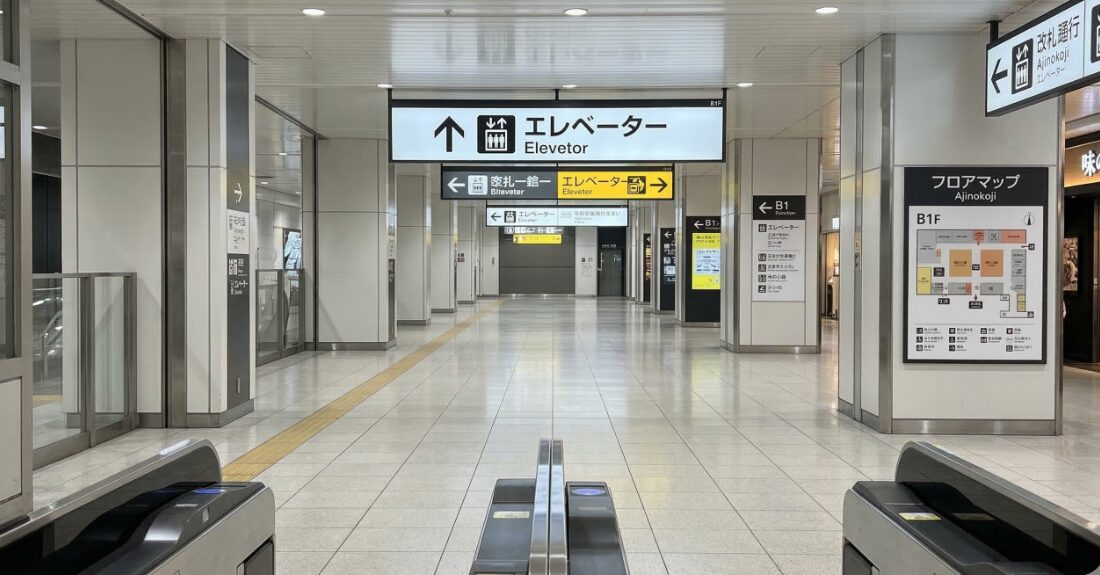改札から見下ろす、広く明るい駅構内。エレベーターの案内サインが少し見えている安心感のある写真