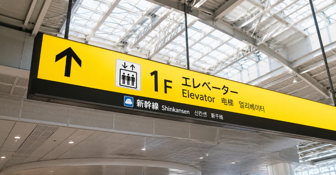 新大阪駅構内の「1階」を示す案内表示を見上げる視点